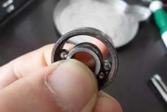 用手將軸承拿起，需要注意要向有滾珠的方向頂住